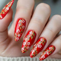 Red nail polish with floral designs on a hand, Obroi