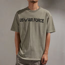 Person wearing a green t-shirt with 'US Air Force' text and logo on a plain background, Obroi