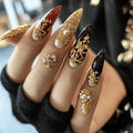 Close-up of a hand with intricately designed nails featuring gold and black patterns, Obroi