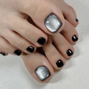 Close-up of toes with black and silver glitter nail polish on a neutral background, Obroi
