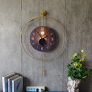 Decorative wall clock with gold frame and brown face on a concrete wall, Obroi