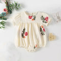 Baby romper with floral embroidery on a white background, Obroi