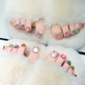  toes with colorful nail polish on a fluffy white surface, Obroi
