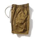 Brown shorts with drawstring on a white background, branded 'Obroi'.