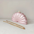 Pink shell-shaped handbag with a gold chain on a white background, Obroi