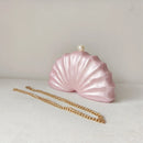 Pink shell-shaped handbag with a gold chain on a white background, Obroi