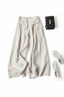 Light-colored wide-leg pants with a black handbag and white shoes on a white background, Obroi