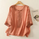 Peach-colored blouse with intricate patterns on a hanger against a light background, Obroi