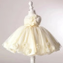 A cream-colored toddler party dress with a tulle skirt and 3D floral embellishments, displayed on a white child-sized mannequin dress form against a light gray background, Obroi