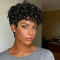 Woman with short, curly black hair wearing a gray shirt indoors, Obroi