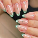 Nails with a gradient design transitioning from pink to green, featuring small decorative elements, Obroi