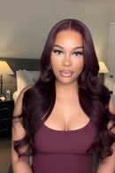 Woman with long, wavy purple hair wearing a matching purple top in a bedroom setting, Obroi