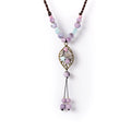 Obroi Necklace with pastel beads and a decorative pendant on a white background