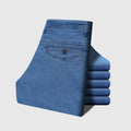 Folded blue jeans with Obroi branding on a light gray background
