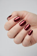 Hand with red and black striped nail polish on a neutral background, Obroi