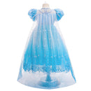 A children's blue fairy tale princess dress displayed on a dress form against a plain white background. The dress features a light blue tulle overlay with silver embroidered snowflake patterns, a solid light blue underlayer, and puffed sleeves, Obroi