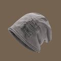 Gray beanie with a textured patch on a brown background, Obroi