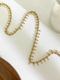 Gold necklace on a white surface, Obroi