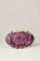 Purple glass clutch with gold accents on a light gray background, Obroi