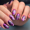 Close-up of hands with purple and pink nail design on a blurred background, Obroi