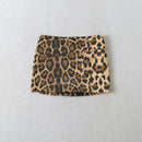 A leopard print mini skirt in a textured woven fabric, displayed flat against a light gray textured background, Obroi