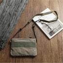Green crossbody bag on a wooden surface with a book and glasses, Obroi