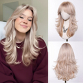 Woman with long blonde hair next to a wig on a mannequin head and another wig on a white background, Obroi