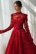 Red embroidered dress with long sleeves against a white curtain background, Obroi