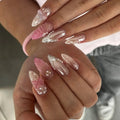 Close-up of hands with decorative nails featuring pink butterflies and pearls, Obroi