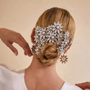 Woman with intricate hairpiece featuring pearls and crystals on a beige background, Obroi