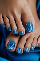 Nails with blue nail polish and white lightning designs on a blue background, Obroi