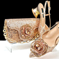 Gold glittery clutch and high heels with rose design on a white background, Obroi