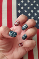 Hand with star-patterned nails against an American flag background, Obroi