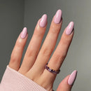 Hand with pink nail polish and a ring on a neutral background, Obroi
