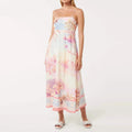 Woman wearing a floral dress with 'VGH' branding on a white background