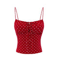 Red camisole top with white polka dots, featuring thin shoulder straps, a sweetheart neckline, and a front tie closure, shown against a plain white background, Obroi