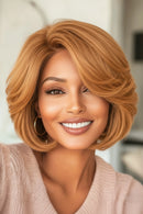 Woman with styled blonde hair wearing a pink sweater indoors, Obroi
