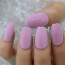 Close-up of a hand with pink textured nails against a blurred background ,Obroi