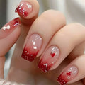 Nails with red and clear gradient design featuring small heart shapes, Obroi