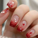 Nails with red and clear gradient design featuring small heart shapes, Obroi