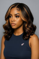 Woman with styled hair wearing a navy blue top on a gray background, Obroi
