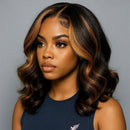Woman with styled hair wearing a navy blue top on a gray background, Obroi