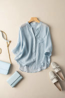 Light blue shirt on a hanger with accessories on a beige surface, Obroi