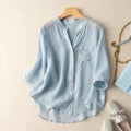 Light blue shirt on a hanger with accessories on a beige surface, Obroi