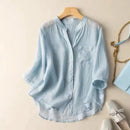 Light blue shirt on a hanger with accessories on a beige surface, Obroi