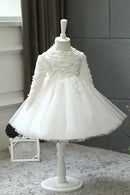 White lace dress on a mannequin against a gray wall with a plant in the corner, Obroi