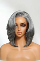 A gray bob wig with layered, side-swept bangs displayed on a mannequin head against a light gray background, with the brand name Obroi in the top left corner.