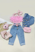 A styled flat lay of a children's outfit set on a light beige background, featuring light blue denim jeans, a pink feather-trimmed camisole top, a pink bow headband, a pink studded mini handbag, pink lace-up boots, and a pink toy camera, Obroi
