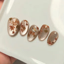 Decorative nail art with floral and bird designs on a white background, Obroi