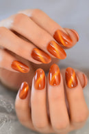 Close-up of hands with orange marbled nail polish on a neutral background, Obroi